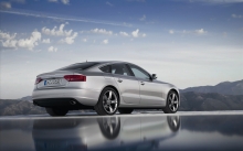 Серебристый Audi A5 задумался, глядя на величественные горы